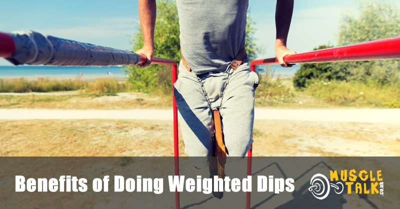 man doing weighted dips on parallel bars